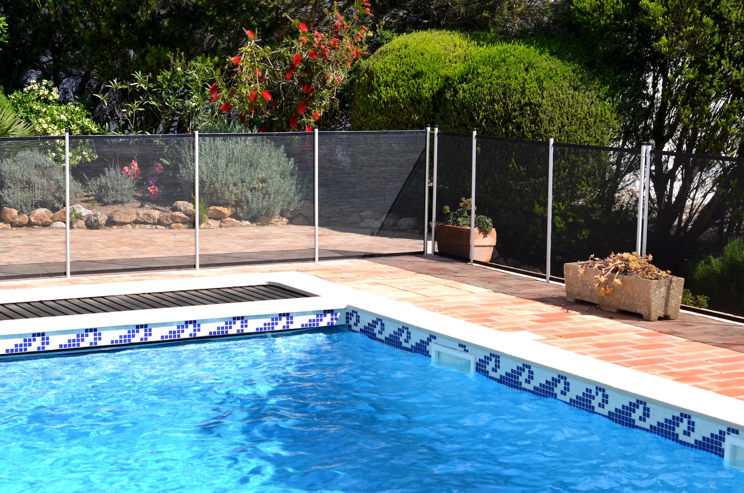 Frameless glass pool fencing with a water feature