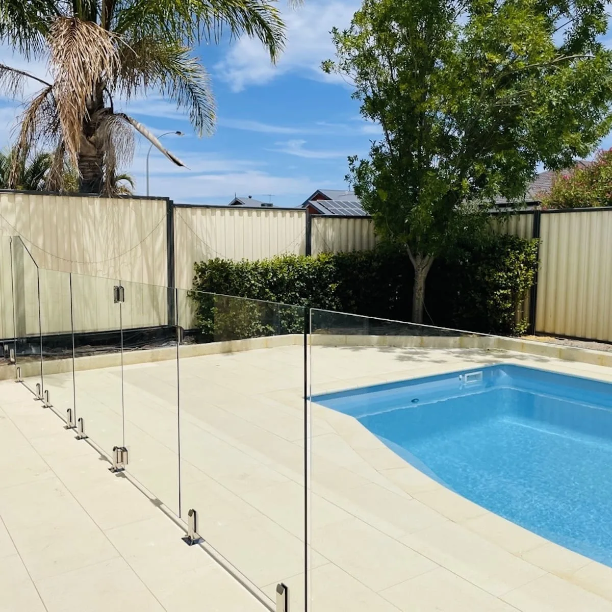 Frameless glass pool fencing in a landscaped backyard